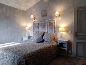 a bedroom with a large bed and two lamps at Côté Chapelle in Coursegoules