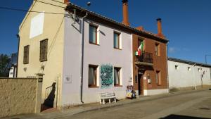 a white building with a mural on the side of it at Albergue San Bruno in Moratinos