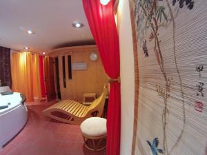 a bathroom with a tub and a toilet and red curtains at Centre ViaYoga in Saint-Cergue