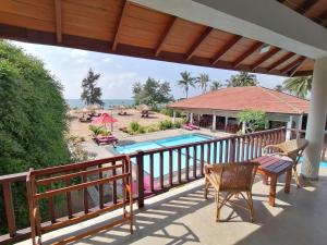 a balcony with a table and chairs and a pool at Ladja Beach Resort in Ambalantota