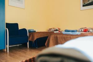 Zimmer mit einem Tisch und einem blauen Stuhl in der Unterkunft Kallaste Hostel in Kallaste