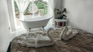 uma cama com toalhas e uma banheira num quarto em 7 Boutique Hotel em Öskemen