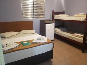 a room with two bunk beds and a table with towels at Pousada Beira Mar in Santos