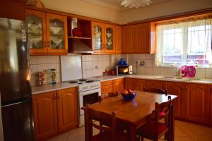 a kitchen with wooden cabinets and a table with a bowl on it at Vasw Apartment in Ágios Nikólaos