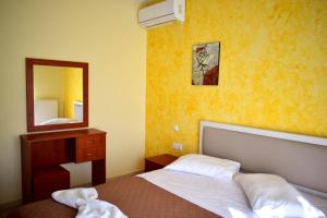 a bedroom with a bed and a mirror at Vasw Apartment in Ágios Nikólaos