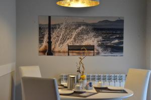 a dining table with chairs and a picture of a wave at H2o in Sirmione