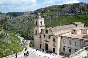an old church with a mountain in the background at La Casa Nei Sassi in Matera