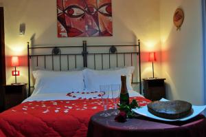a bed with a bottle of wine and a cake on a table at La Casa Nei Sassi in Matera