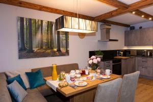 uma cozinha e sala de jantar com uma mesa de madeira e uma sala de jantar em Appartement Enzian & Mark em Ellmau