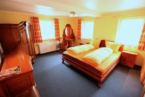 a bedroom with a large bed and two windows at Gelber Löwe B&B Nichtraucherhotel in Schwabach