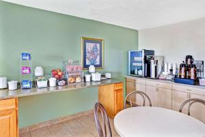 a dining room with a table and chairs and a counter at Super 8 by Wyndham Mokena/Frankfort /I-80 in Mokena