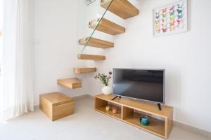 a living room with a flat screen tv on a wooden stand at Villa Brac with pool Bol in Bol