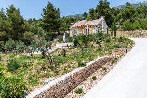 a house on a hill next to a road at Villa Brac with pool Bol in Bol