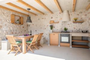 a kitchen with a wooden table and chairs at Villa Brac with pool Bol in Bol