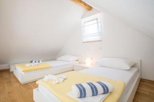 two beds in a room with white walls at Villa Brac with pool Bol in Bol +11 photos