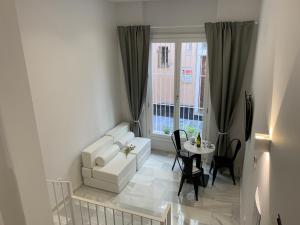 a living room with a white couch and a table at San Lorenzo Apartamentos y Suites in Cádiz