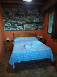 a bedroom with a bed with two towels on it at Apartamentos Borda Falceto in Coscojuela de Sobrarbe