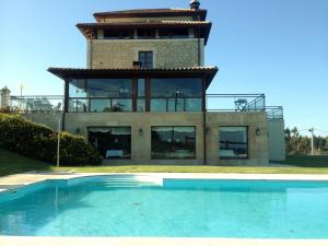 a house with a swimming pool in front of a building at Hotel Villadesella in Ribadesella