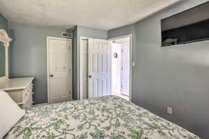 a bedroom with a bed with a floral bedspread at 1 Block to Ocean Shore Condo in Myrtle Beach! in Myrtle Beach +16 photos