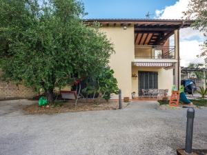 una casa con un árbol y un parque infantil en Comfortable Villa in Roma with Garden and Barbecue, en Roma