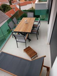 un tavolo in legno e sedie sul balcone. di SEAVIEW ROGOZNICA a Rogoznica (Rogosnizza)