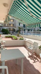 a patio with a table and chairs on a building at El Palmar Residence Vista-Mare e Vista-Piscina in Lido di Jesolo