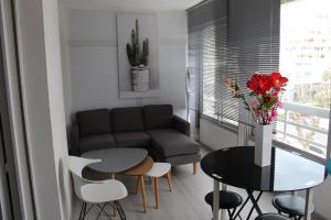 uma sala de estar com um sofá, uma mesa e cadeiras em APPT T2 - BEN - La Grande Motte em La Grande-Motte