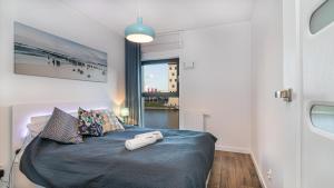 sypialnia z łóżkiem i dużym oknem w obiekcie Leopold Winter Residence - BillBerry Apartments w Gdańsku