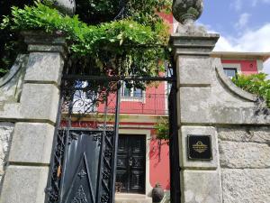 a gate to a pink house with a black door at Solar da Motta Douro Boutique Home in Ancede