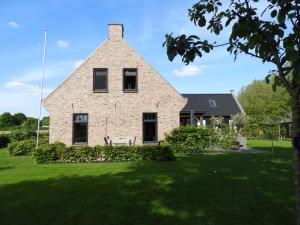 a large brick house with a grass yard at Bed & Breakfast Bennekom in Bennekom