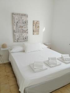 a white bed with two white towels on it at La Finestra su Stintino in Stintino