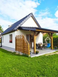 a small white house with a patio at #MazuryNature in Giżycko