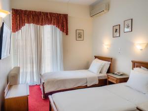 pokój hotelowy z 2 łóżkami i oknem w obiekcie Hotel Elena w mieście Larisa
