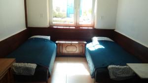 グダニスクにあるAlexandria Apartmentのベッド2台と窓が備わる小さな客室です。