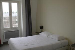 a bedroom with a white bed and a window at Résidence d'Artagnan in Montargis