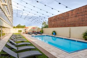 una piscina con sedie a sdraio accanto a un edificio di Hyatt Regency - Greenville a Greenville