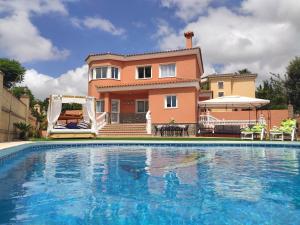 a villa with a swimming pool in front of a house at La Atalaya in Benalmádena