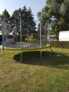 2 enfants jouant sur un trampoline dans l'herbe dans l'établissement Aux Cygnes D'Opale, à Blangy-sur-Bresle