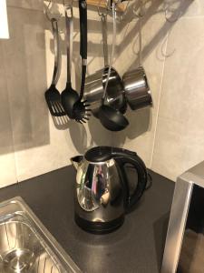 a tea kettle and utensils on a kitchen counter at Thistle Apartment, Inverness in Inverness