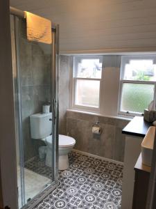 a bathroom with a toilet and a glass shower at Thistle Apartment, Inverness in Inverness