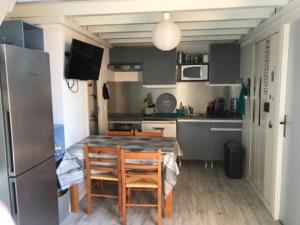 a kitchen with a table and chairs and a refrigerator at Port leucate T2 bis wifi les Sables 3 in Port Leucate