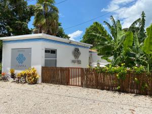 a small white building with a wooden fence at Aljanna House in Bacalar