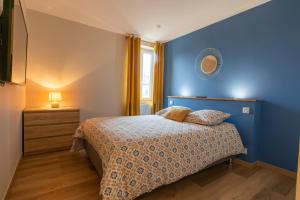 Dormitorio azul con cama y espejo en Gîtes à côté de Chambord, Blois, Cheverny, en Saint-Claude-de-Diray