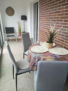 ein Zimmer mit einem Tisch, Stühlen und einer Ziegelwand in der Unterkunft Cabourg plage à 200m plage in Cabourg