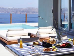a tray of food on a table next to a pool at Melidonia Suites in Akrotiri