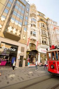 un tranvía rojo en una calle de la ciudad con edificios en Golden Street Hotel, en Estambul