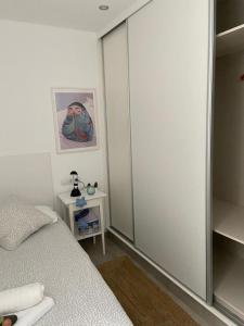 a bedroom with a bed and a sliding glass door at Durmiendo sobre el mar, El Echadero in Telde