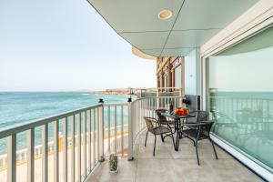 een balkon met een tafel en stoelen en de oceaan bij Durmiendo sobre el mar, El Echadero in Telde