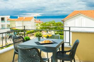 stół i krzesła na balkonie z widokiem na ocean w obiekcie Apartments Villa Fe w mieście Malinska