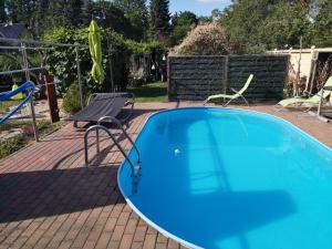 a blue swimming pool with a chair and a swing at Ferienwohnung-gurran in Lübben